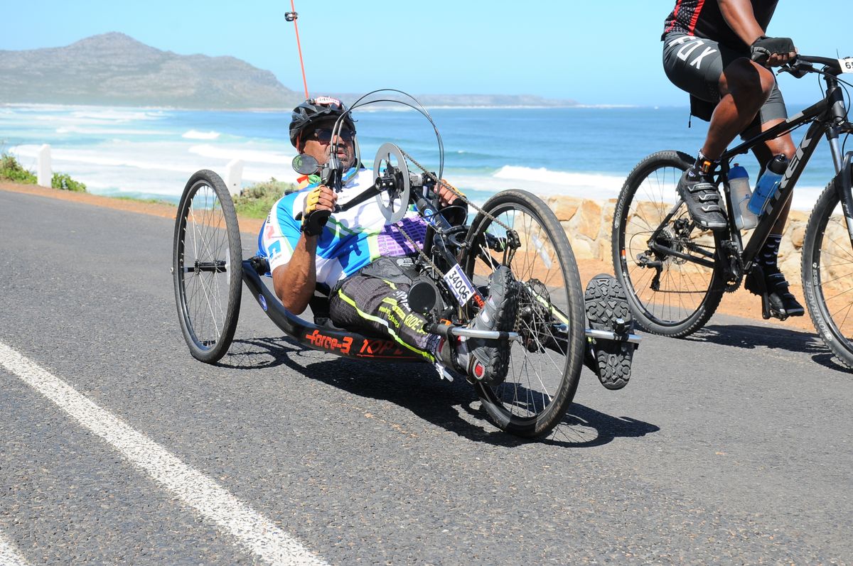 Athlete using a hand-powered adaptive cycle on an open road