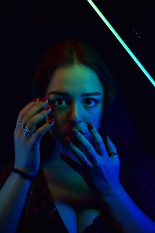 Free Dramatic portrait of a woman under blue and red lighting, emphasizing mystery and emotion. Stock Photo