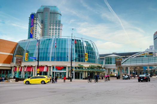 Modern architectural shopping mall facade in urban cityscape with traffic.