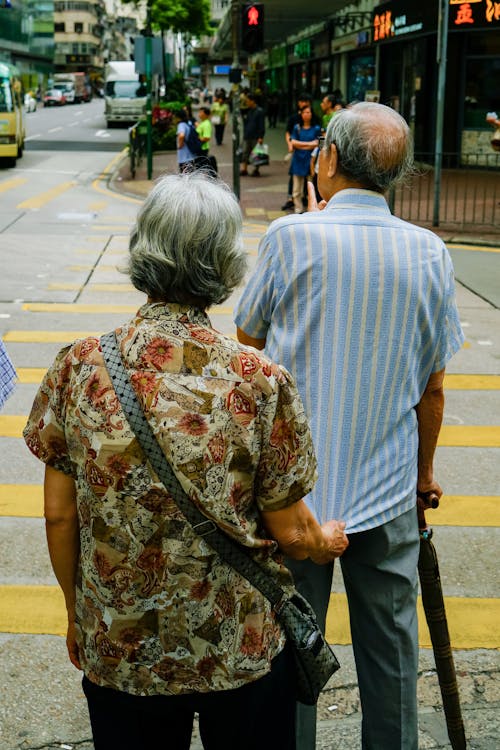 Man and Woman Standing Beside Pedestrian Lane