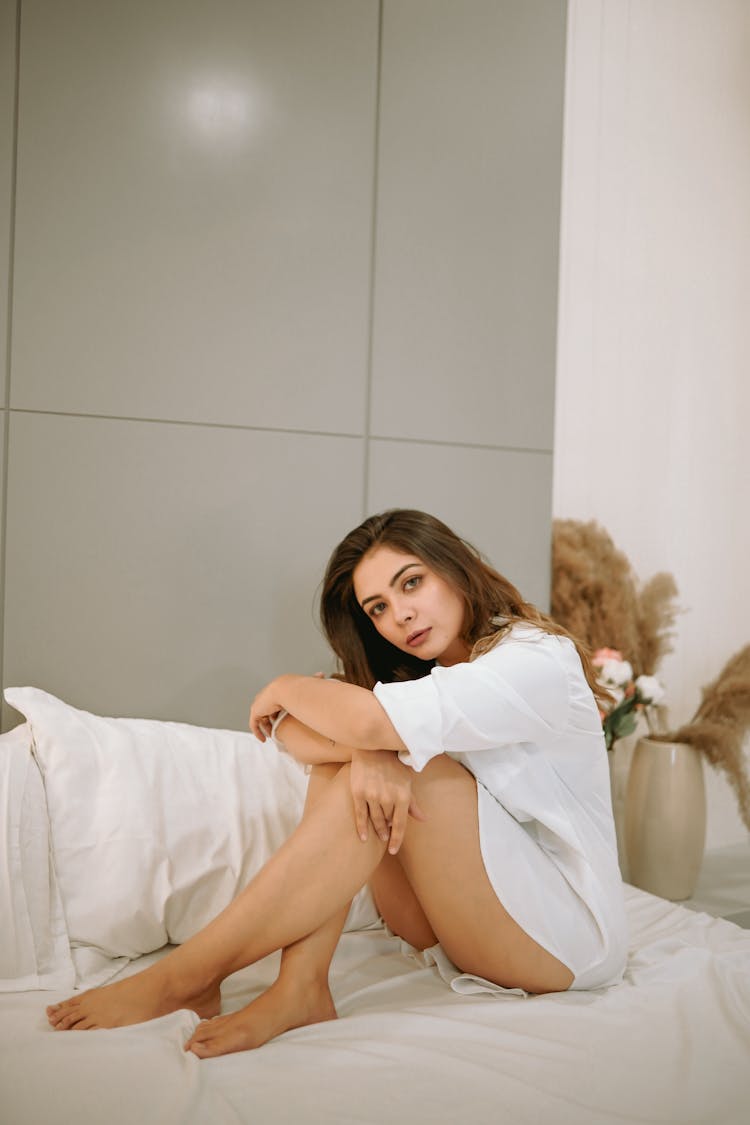 Woman In Shirt Sitting On Bed