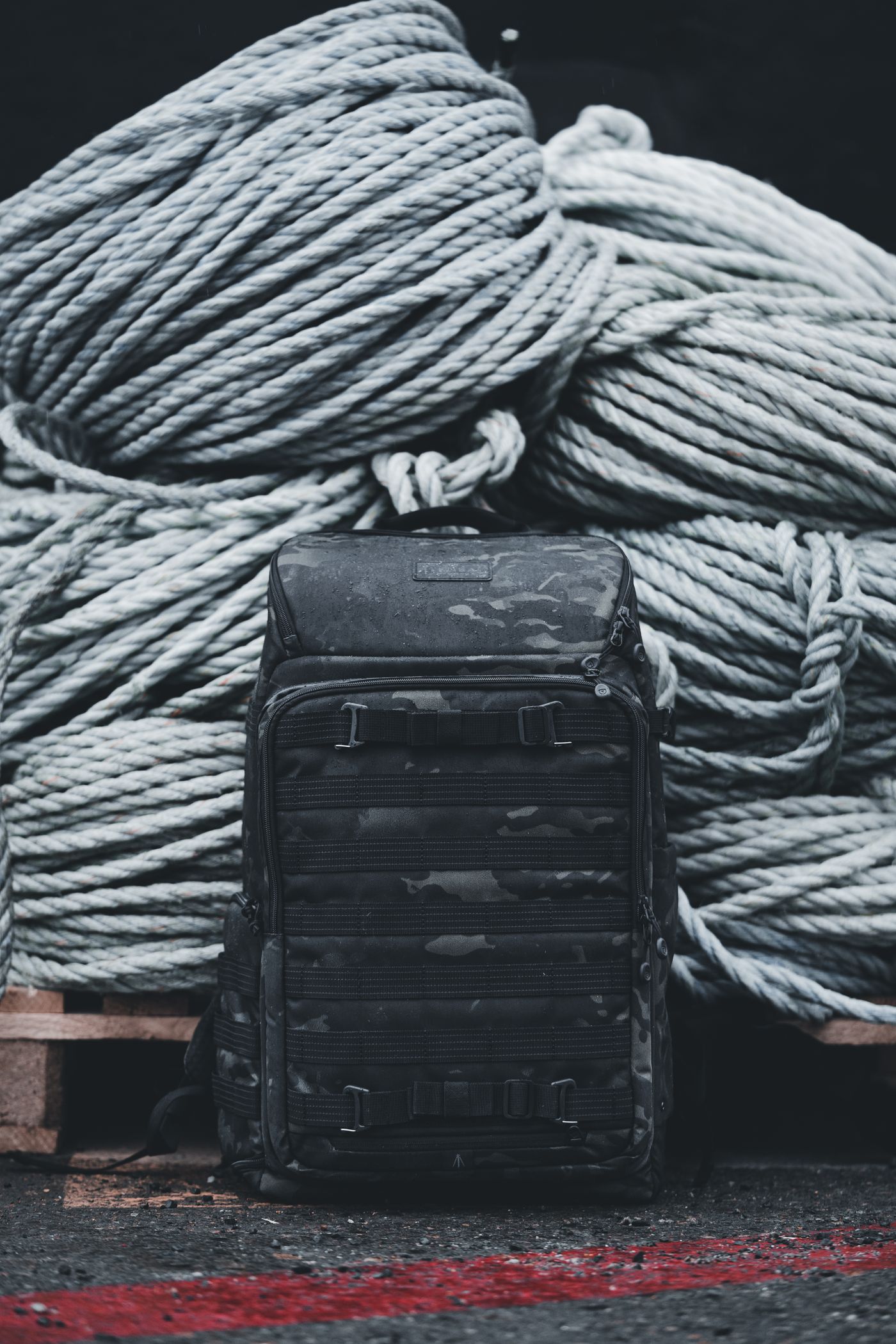 Rugged outdoor backpack positioned beside organized coils of rope