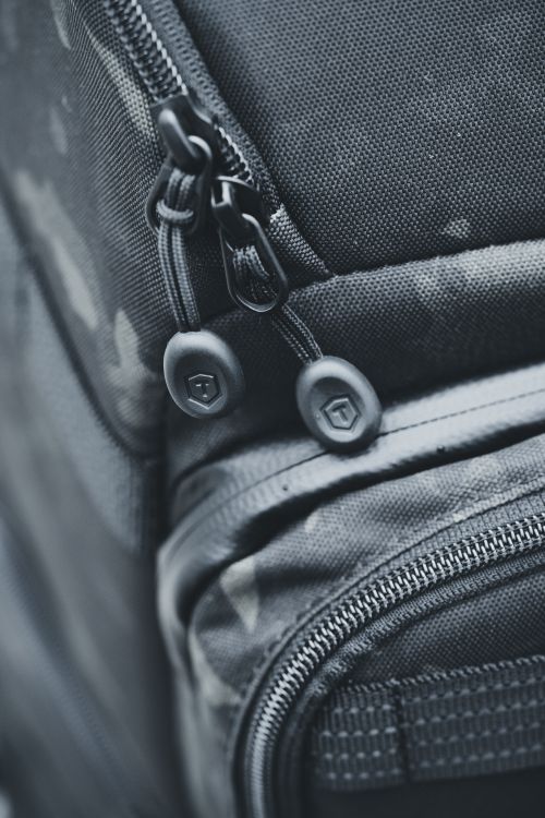 Free Detailed close-up of a rugged travel backpack with a focus on the zipper and fabric texture. Stock Photo