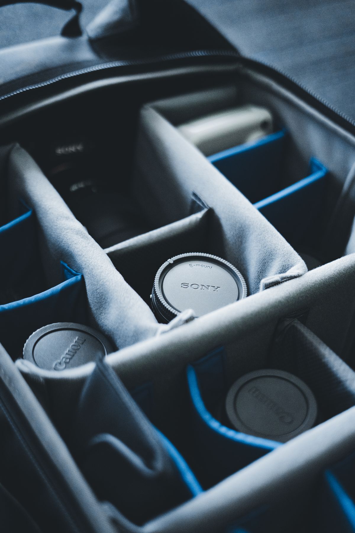 Close-up of camera lenses stored neatly in individual padded compartments inside a travel bag
