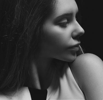 Artistic black and white portrait of a woman in a profile view.