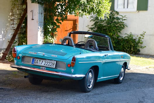 一辆经典的绿松石雷诺敞篷车停在阳光明媚的花园里