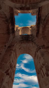 Explore ancient sandstone arches with a stunning blue sky backdrop, showcasing historical architecture.