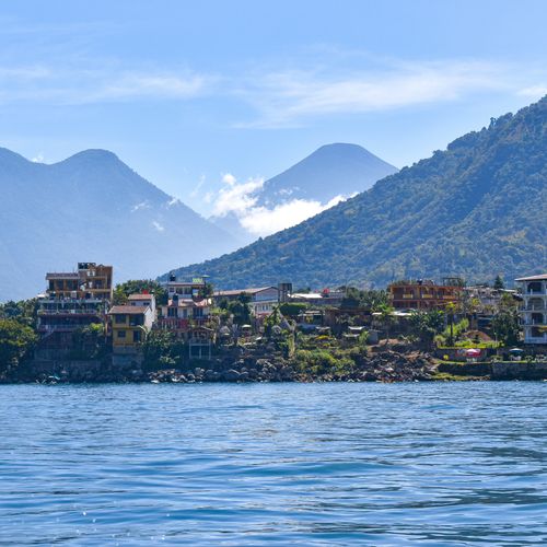 Free Beautiful Lake Atitlan with mountains and a village, perfect travel destination in the Guatemalan Highlands. Stock Photo