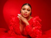 Portrait of an elegant woman in a vibrant red gown, showcasing fashion and beauty.