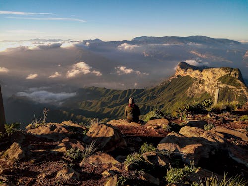 Woman Sitting on the Top of the Mountain and Admiring the View of the Mountain Range