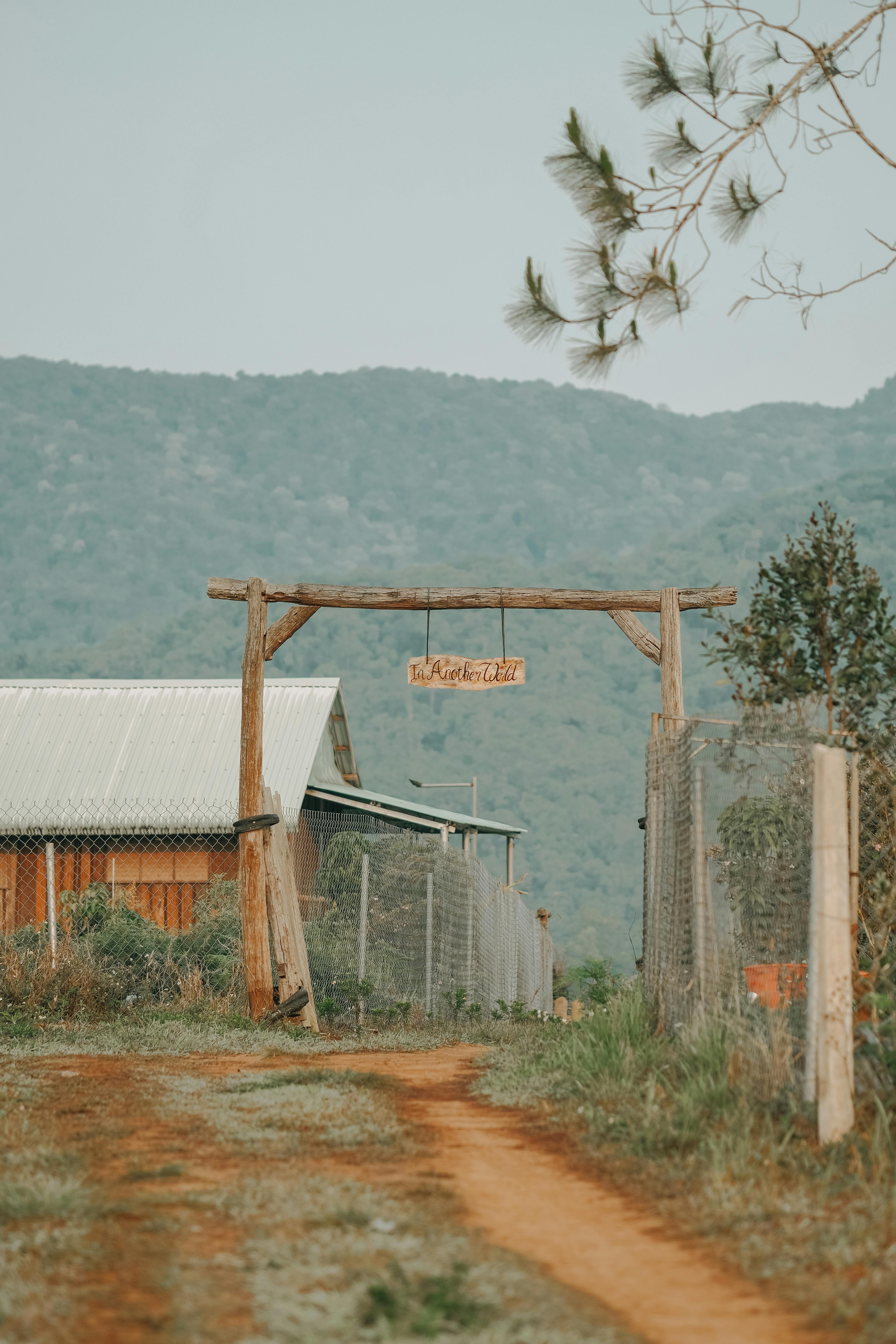 Charming farmhouse entrance with wooden gate and mountain view, ideal rural scenery.