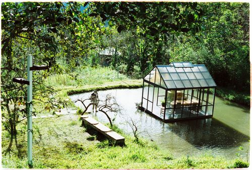 Free A serene floating glass house on a pond surrounded by lush greenery, ideal for nature lovers. Stock Photo