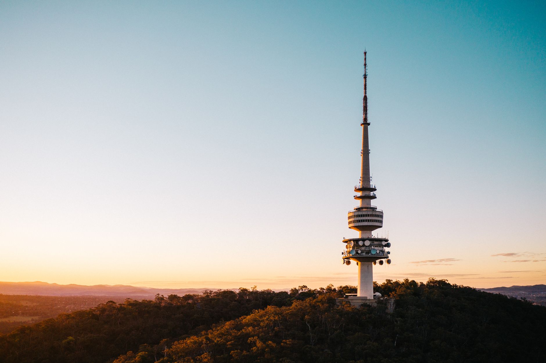 A stunning view of Telstra Tower on Black Mountain at sunset in Canberra, Australia.