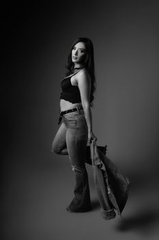 Black and white portrait of a model posing in a studio wearing denim and crop top.
