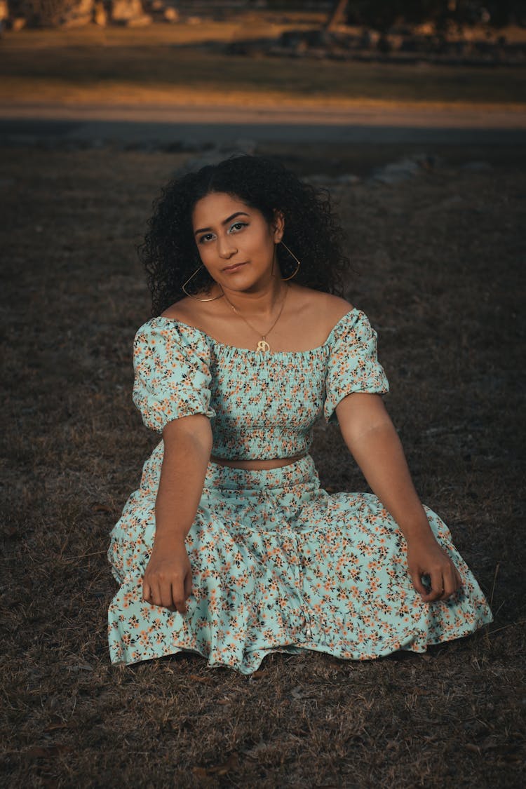 Young Woman In A Summer Outfit Sitting Outdoors 