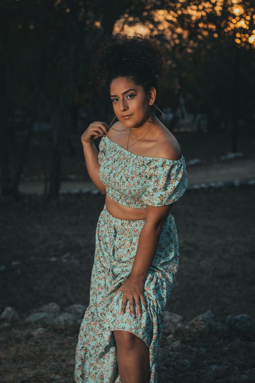 Free Stylish woman in floral crop top and skirt during sunset outdoors. Stock Photo