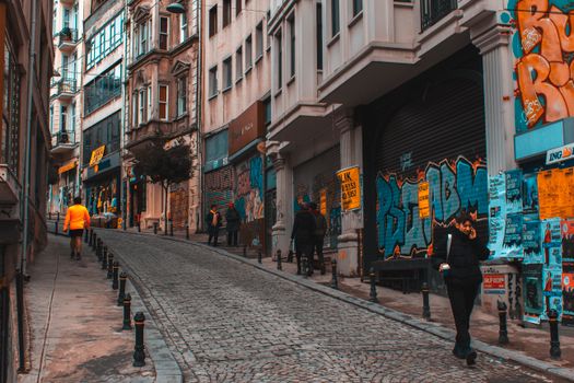 Colorful urban alley capturing daily life with graffiti art and diverse architecture.