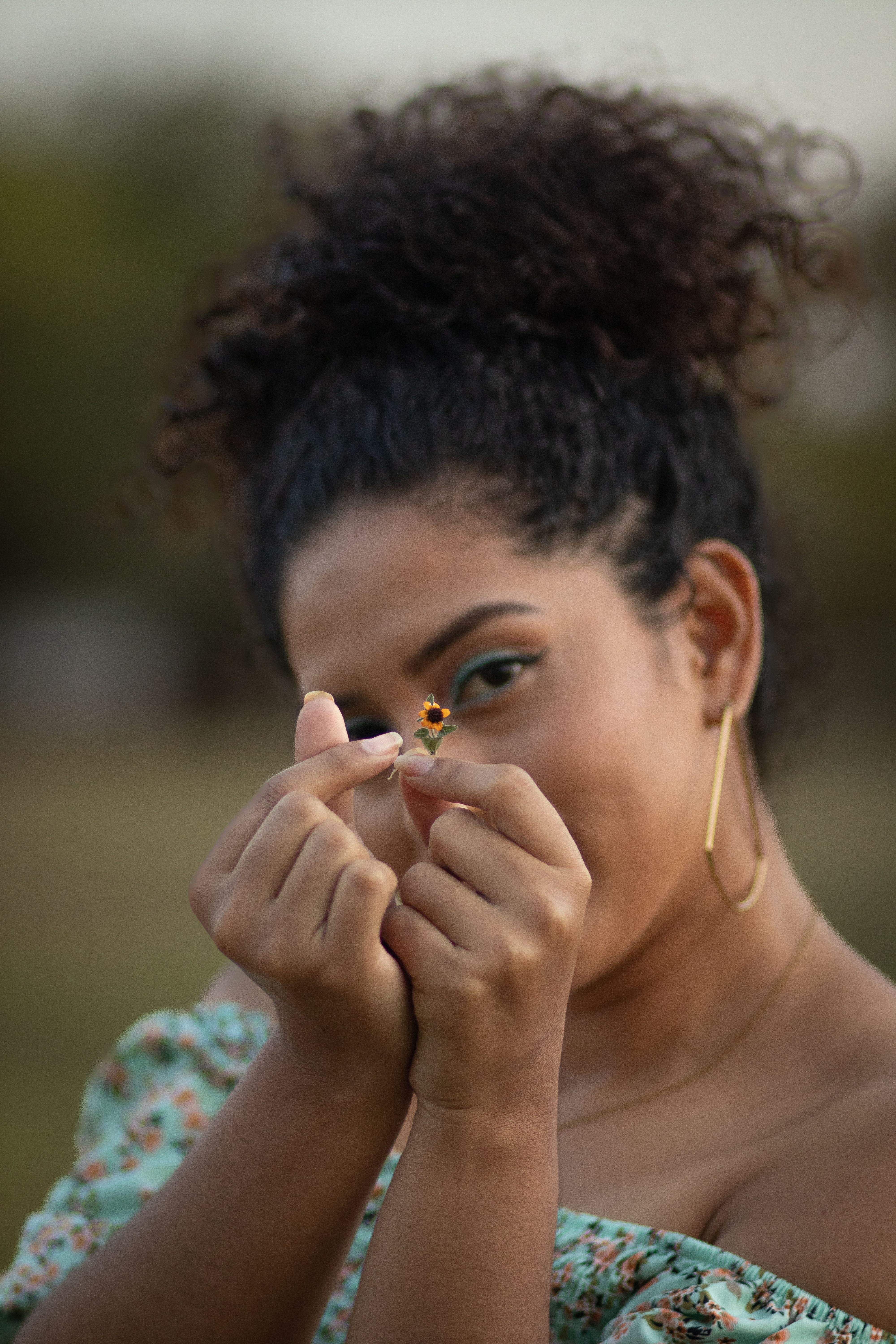 Pretty Woman Holding a Tiny Flower in front of Her Face · Free Stock Photo