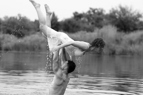 A man and woman are in the water holding each other