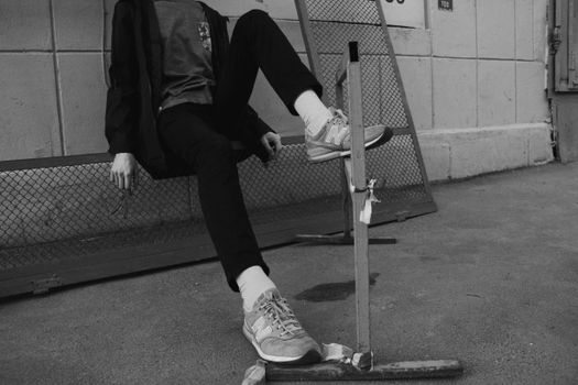 Stylish street portrait in black and white featuring casual fashion and footwear.