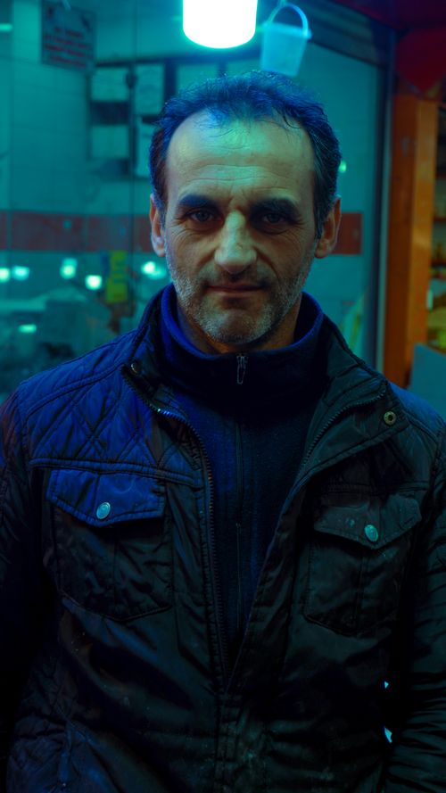 Free Middle-aged man in winter jacket in city lights, urban atmosphere. Stock Photo
