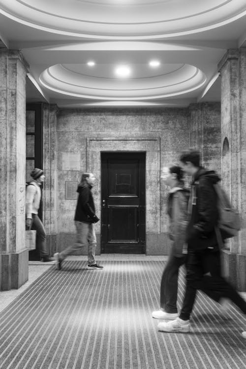 People Walking in Corridor in Black and White