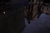 黄昏时，城市水坑中倒映着建筑物和人的艺术景象