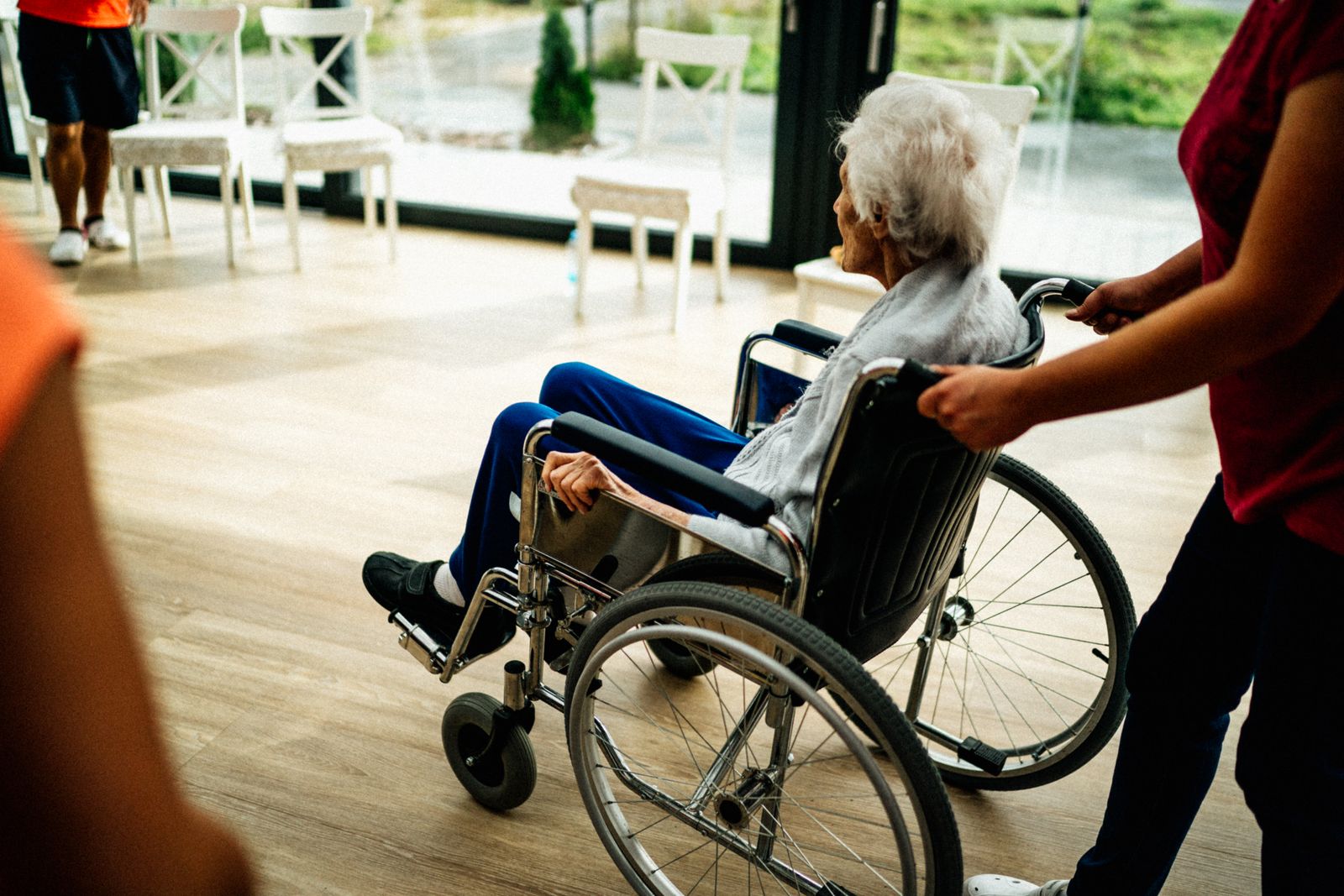Caregiver assisting a senior adult in a wheelchair in a nursing home