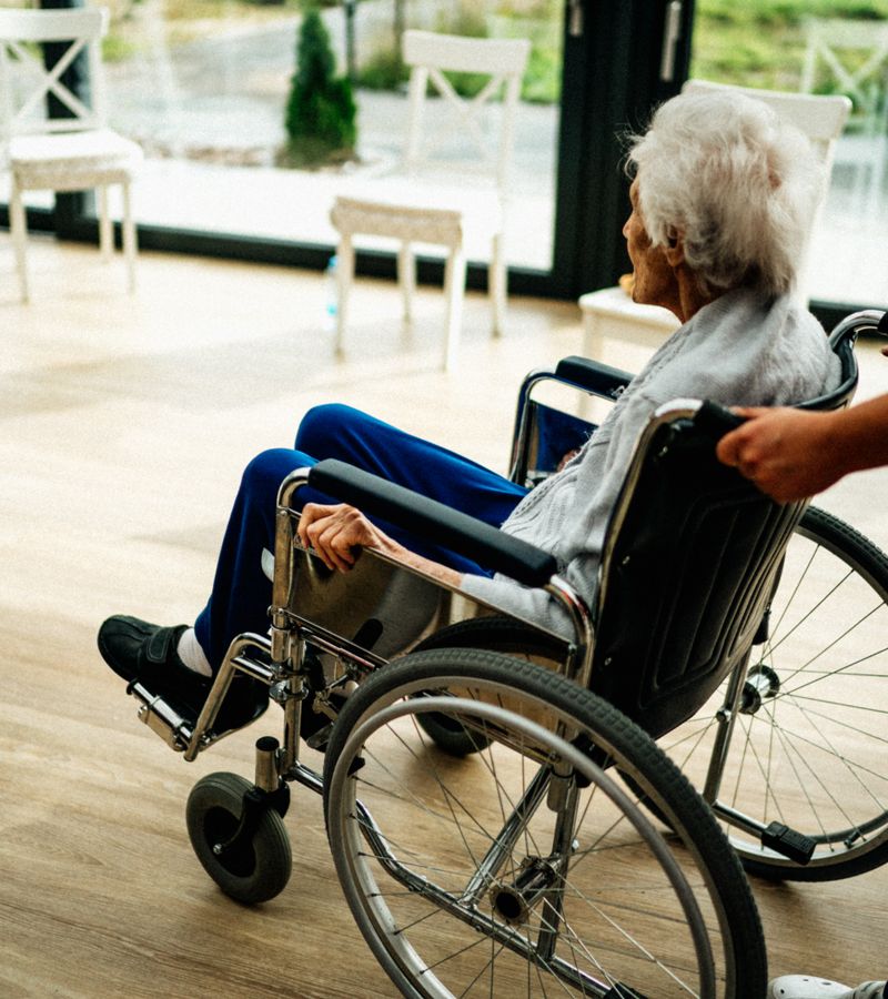 A caregiver assists a senior adult in a wheelchair at a nursing home in Prague, Czech Republic.