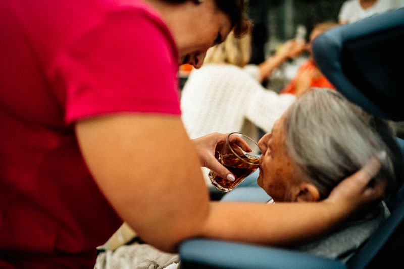 Caregiver serving tea to elderly patient