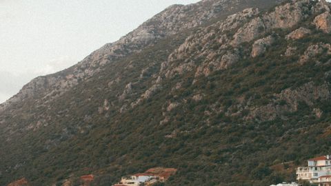 Charming village nestled in the mountains under a clear sky, highlighting a serene landscape.