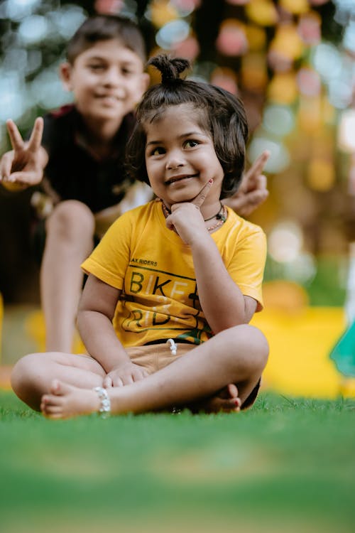 Two Children Sitting on Grass