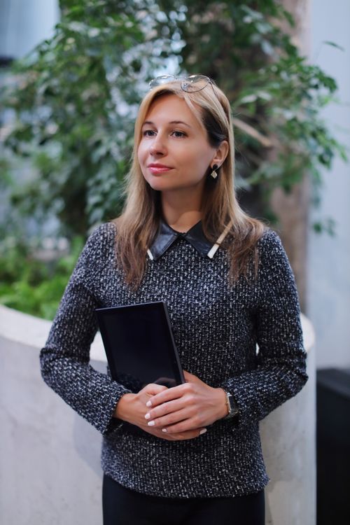 Free Elegant woman with long hair holding a tablet indoors, portraying professionalism. Stock Photo