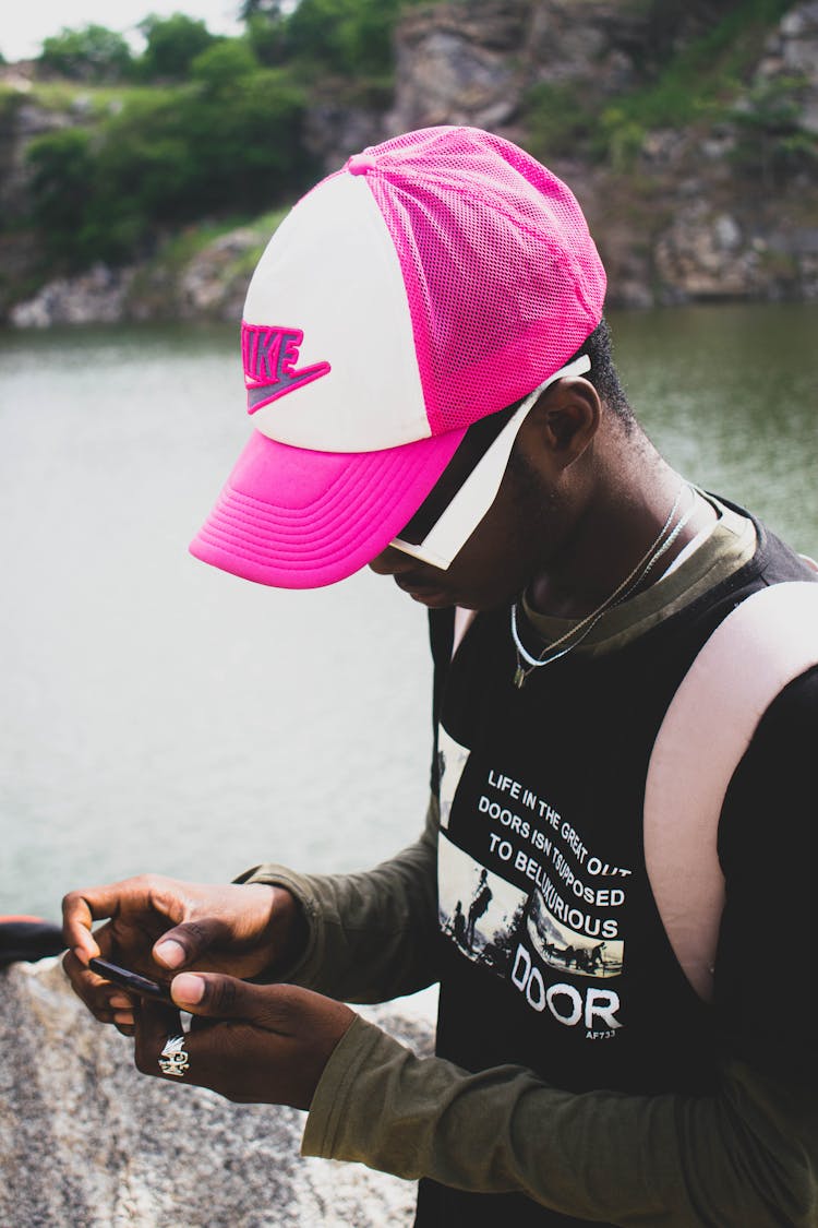 Man In Cap Using Cellphone