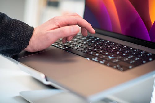 Man Hand over Laptop Keyboard