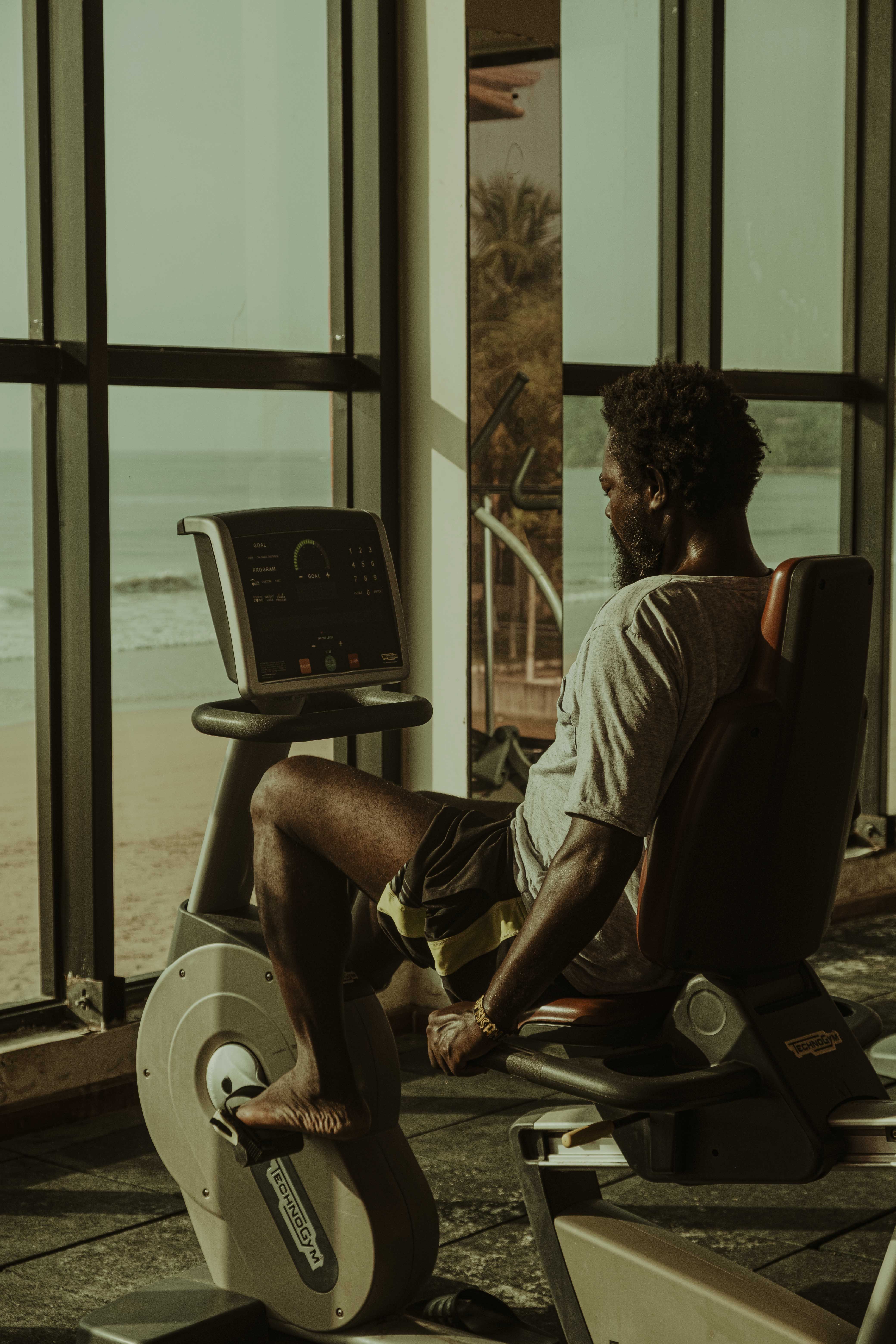 African man working out on an exercise bike at a gym in Kumasi, Ghana.