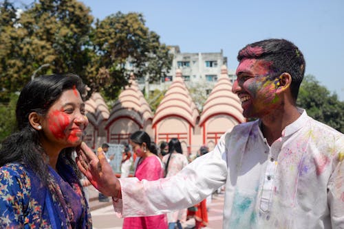 Colorful Powder on Smiling Man and Woman Faces