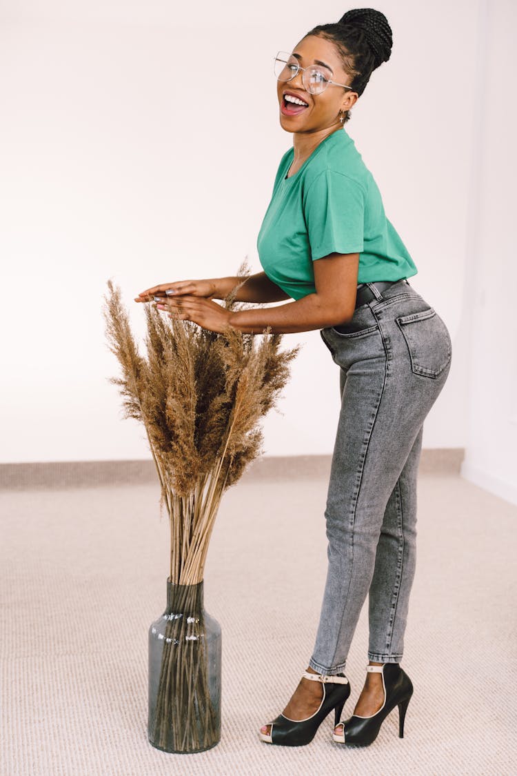 Smiling Woman Posing By Plant In Vase