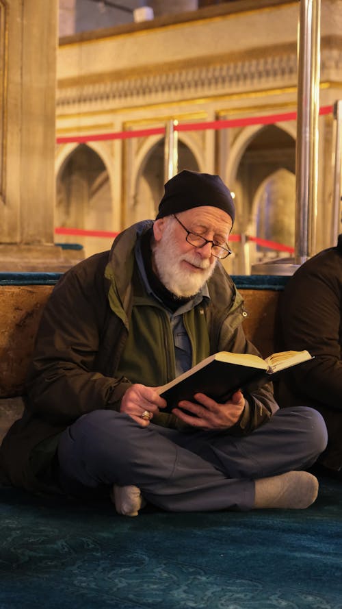 Elderly Man Reading from a Book in a Mosque