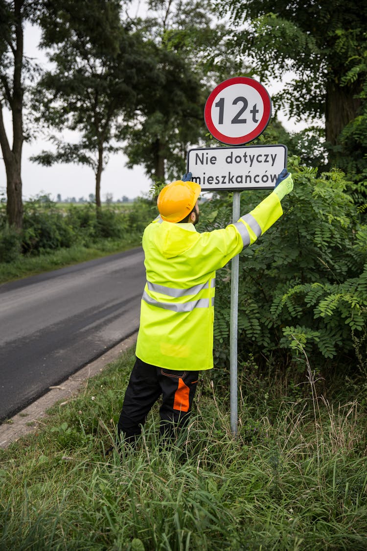 Worker Installing A Road Sign