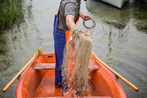 Man Holding a Net on a Boat 