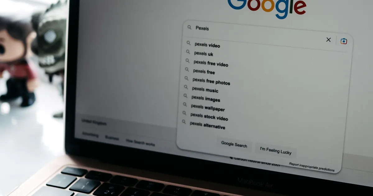 Laptop on a desk displaying a Google search results page with autocomplete suggestions