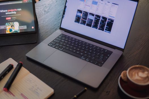 A cozy workspace in Amsterdam featuring a laptop, tablet, and coffee for productivity.