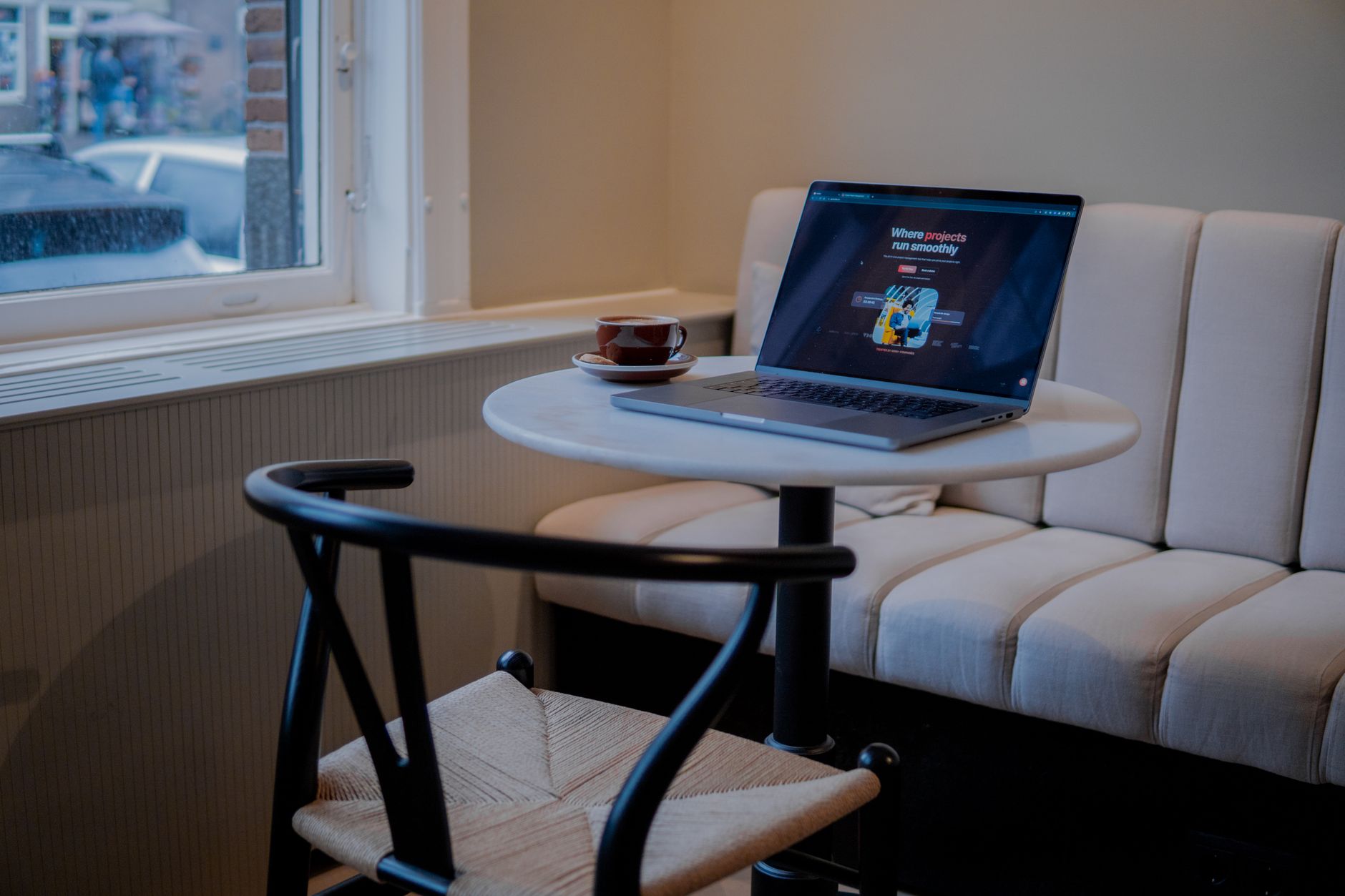 A laptop and coffee on a table in an Amsterdam cafe, perfect for working.