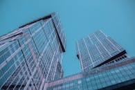 低角度视角下的未来派摩天大楼，反光玻璃外墙映衬着清澈的蓝天