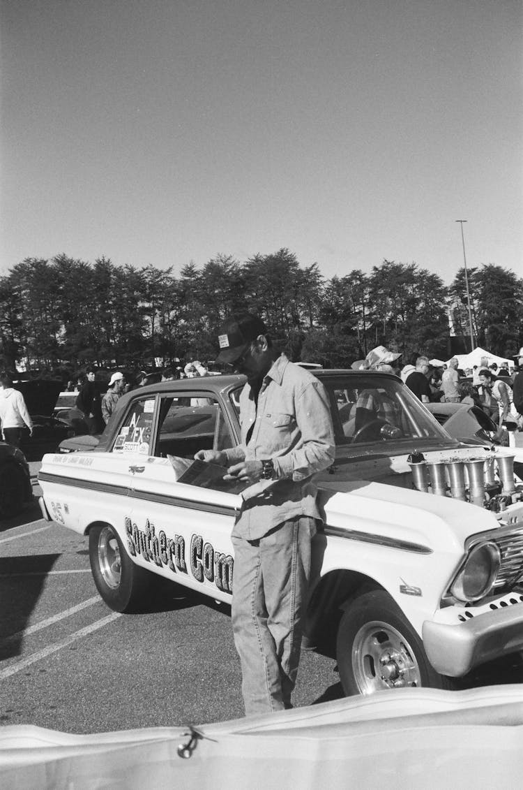 Man Standing Near Vintage Car In Black And White