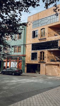 Colorful modern residential building facade in urban street setting, showcasing architectural details.