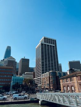 Low angle view of skyscrapers in downtown San Francisco under a clear blue sky, showcasing urban architecture.