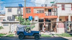 哈瓦那的街景充满活力，复古蓝色吉普车与城市建筑相映成趣