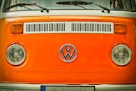 亮橙色的复古大众货车前徽特写，设计经典